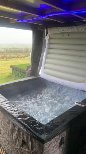 a bed in the back of a camper with water at Glamping Domes in Articlave