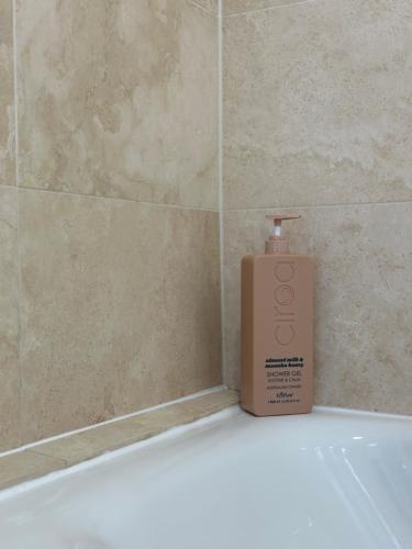 a bottle of soap sitting on top of a bath tub at W9 Gem Stylish 2 Bed Flat in London