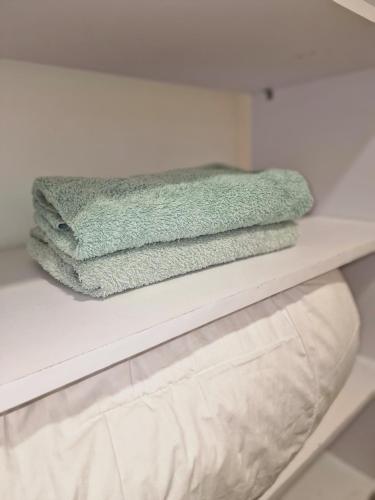 two towels are sitting on a shelf in a bathroom at appartement cosy in Somone
