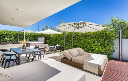 a patio with a couch and a table with an umbrella at 3 Bedroom Gorgeous Home In Pula in Pula