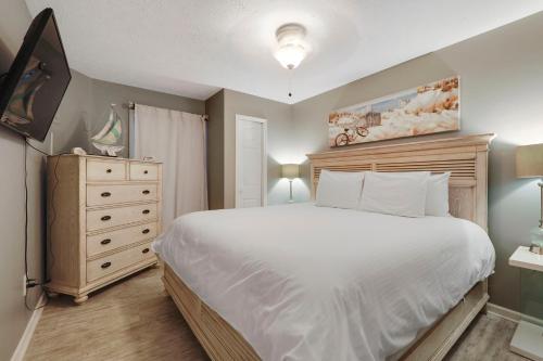 a bedroom with a large white bed and a dresser at 103 Pointes North Inn in Charlevoix