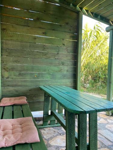 a green picnic table and bench on a patio at EIRINI-Triopetra Sea View Apartments in Triopetra