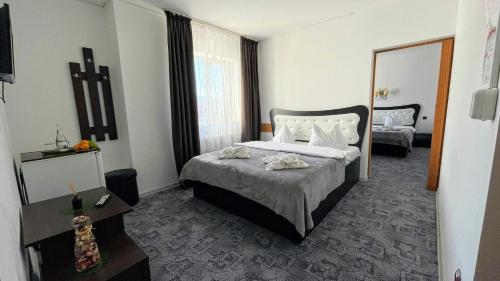 a hotel room with a bed and a mirror at Pensiunea-restaurant Casa Țărănească Bușteni in Buşteni
