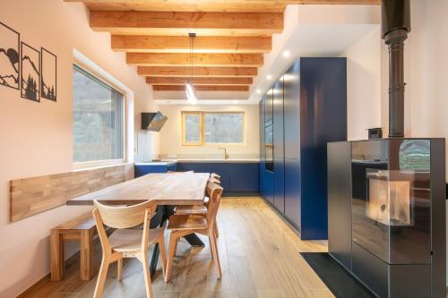une cuisine avec une table et des chaises en bois et un réfrigérateur dans l'établissement Chalet l'Escalet - A 30 min Alpes d'huez, à Ornon