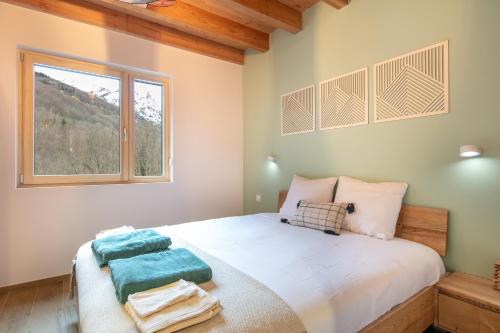 une chambre avec un grand lit avec une fenêtre dans l'établissement Chalet l'Escalet - A 30 min Alpes d'huez, à Ornon