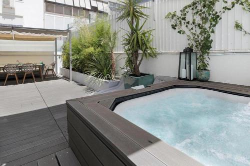 a large hot tub on a balcony with a patio at Flea Market Alfama House (Patio/Pool/AC/Garage) in Lisbon
