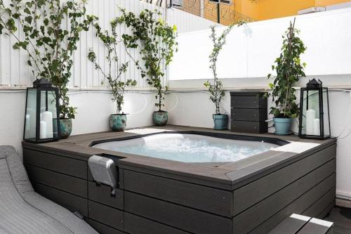 a hot tub in a room with potted plants at Flea Market Alfama House (Patio/Pool/AC/Garage) in Lisbon