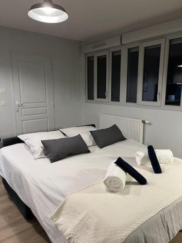 - une chambre avec 2 lits dotés de draps blancs et d'oreillers noirs dans l'établissement Charmant studio, à Villeurbanne
