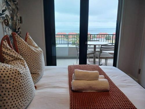 a bedroom with a bed with a view of the ocean at 302 Mossel Cove Sea View Deluxe in Mossel Bay
