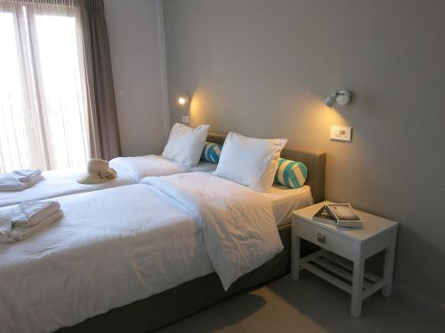 a bedroom with two beds and a night stand at Amaryllis in Plataniás