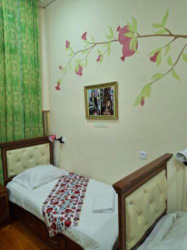 a bedroom with a bed and a tree mural on the wall at Art Hostel in Tashkent