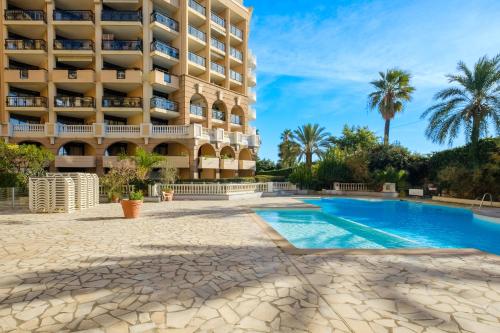 a hotel with a swimming pool in front of a building at Residhotel Villa Maupassant in Cannes