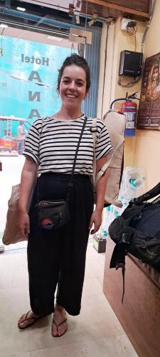 a woman standing in a room with a purse at Hotel Ananya Inn in Varanasi