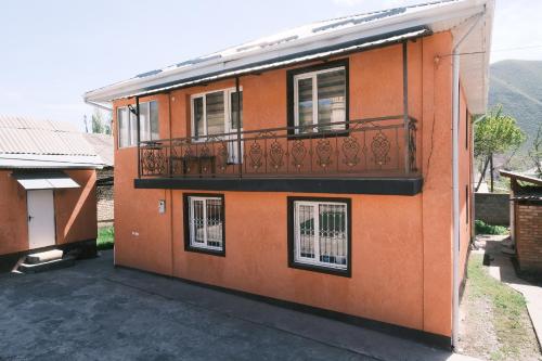 an orange building with a balcony on the side of it at Gulcha in Gultscha