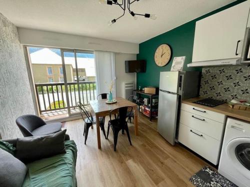 une cuisine et une salle à manger avec une table et un réfrigérateur dans l'établissement Appartement Cosy 4 personnes au coeur des Pyrénées, à Vielle-Aure