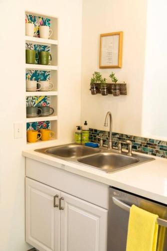 a kitchen with a sink and a shelf with plants at Artsy Half-House, Walk to Hiking Trails &Wine Bars! Yard, Firepit in Sedona