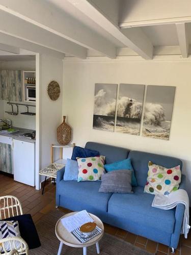 un soggiorno con un divano blu e una cucina di Maison des Dunes a Le Touquet-Paris-Plage