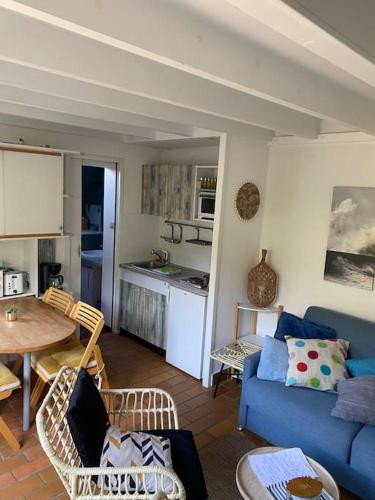 un salon avec un canapé bleu et une table dans l'établissement Maison des Dunes, à Le Touquet-Paris-Plage