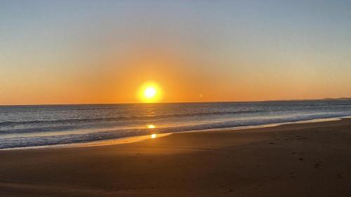 a sunset on a beach with the ocean at Departamento en Green Park in Punta del Este
