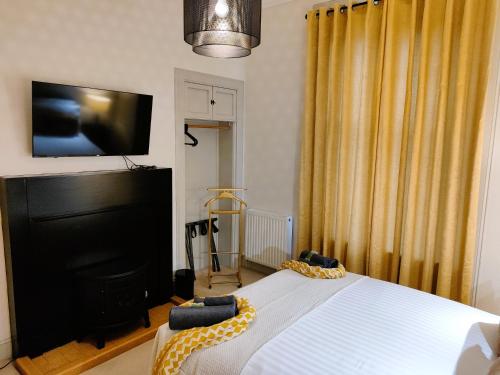 a bedroom with a bed and a flat screen tv at Bella Vista Manor - with elevated views over Rothesay & Loch Striven in Rothesay
