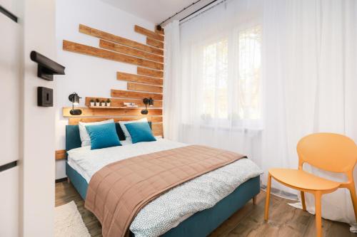 a bedroom with a bed and a table and a chair at Apartament Blues, ul Jastrzębia in Lublin