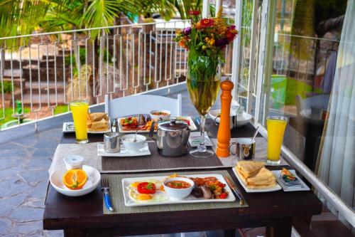 a table with breakfast food and a glass of orange juice at Room 1 of 8 Cozy Suites at The Hilltop Guesthouse in Harare