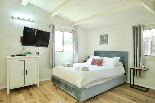 a bedroom with a bed and a flat screen tv at פרדייז ריזורט in Had Nes