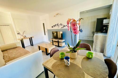 - un salon avec une table et une fleur dans l'établissement Charming T3 with balcony in the heart of Briançon, à Briançon