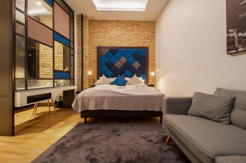a bedroom with a bed and a couch at The Loft Budapest in Budapest