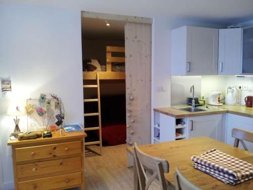 une cuisine et une salle à manger avec une table et une cuisine avec une salle à manger gmaxwell dans l'établissement L'Evasion Alpine, à Huez