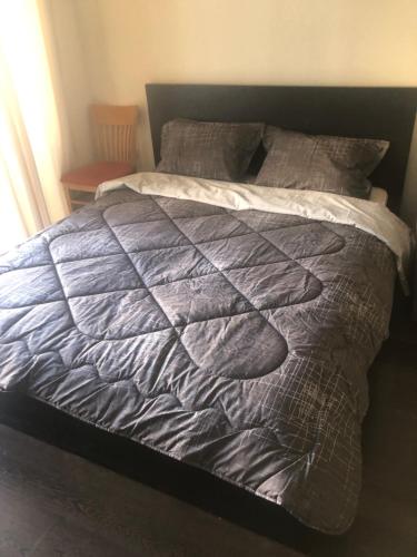 a bed with a gray comforter and pillows at Bendita Mare Golden Sands Bulgaria in Golden Sands