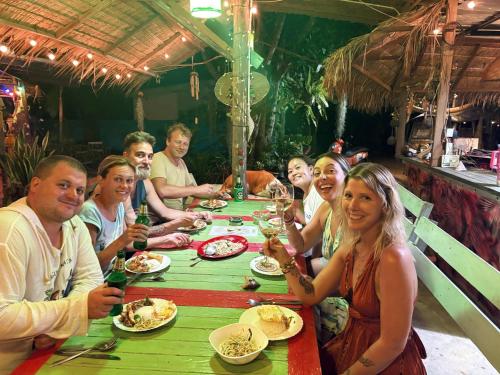 a group of people sitting at a table eating food at Freedom home in Ko Chang