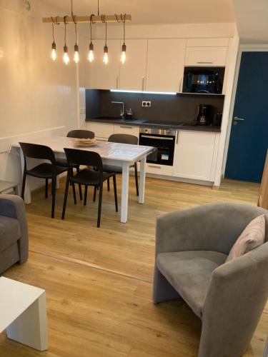 une cuisine et un salon avec une table et des chaises dans l'établissement Appartement 6 personnes dans résidence avec piscine, à Le Touquet-Paris-Plage
