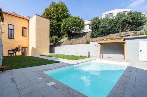 a swimming pool in a yard next to a building at Host Wise - Sunny Bright Duplexes & Pool in Vila Nova de Gaia