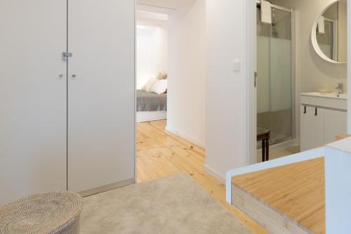 a living room with white walls and a mirror at Host Wise - Sunny Bright Duplexes & Pool in Vila Nova de Gaia