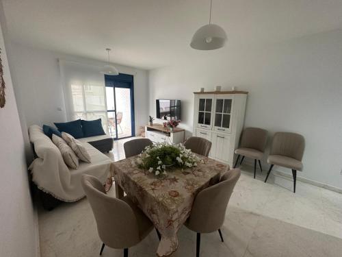 una sala de estar con una mesa y un sofá en Fesemar, en San Juan de los Terreros