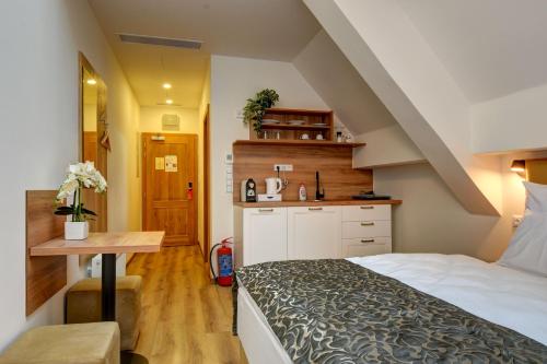 a small bedroom with a bed and a table at Hotel Karlova Prague in Prague