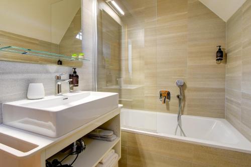 a bathroom with a white sink and a bath tub at Hotel Karlova Prague in Prague