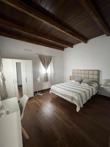 a bedroom with a large bed and a wooden floor at Apartamentos Violante in Tuineje