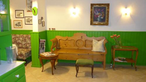a green room with a bed and a table and a chair at Romantisches Hotel Zur Traube Schwerin in Schwerin