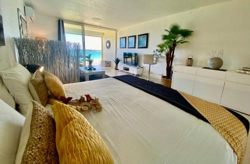 a bedroom with a large white bed with stuffed animals on it at Excellence Suites Orient Beach Oceanview King-Size Beach Pool Parking in Cul de Sac