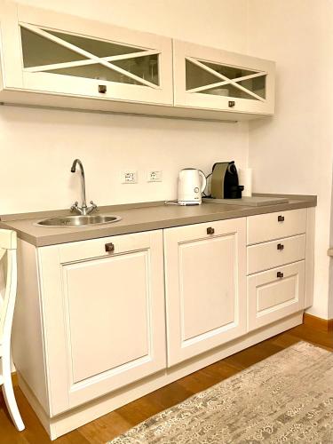 a kitchen with white cabinets and a sink at Residenza Cantore in Verona