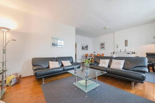 a living room with a leather couch and a glass table at Tower Apartment Centre Sittard in Sittard