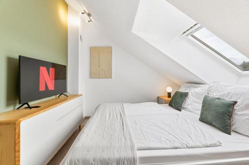 a bedroom with a white bed and a window at The Serviced - Design Apartments in Stuttgart