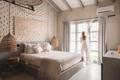 a woman standing in a bedroom looking out the window at GAIA Alaçatı Bazaar in Alacati