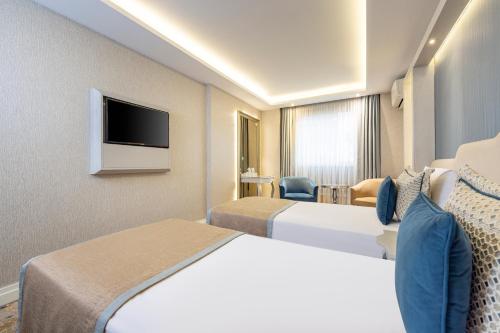 a hotel room with two beds and a flat screen tv at AHC Old City Hotel in Istanbul