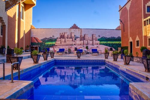 a swimming pool in a courtyard with a mural of a building at lmtounipalace in Ouarzazate