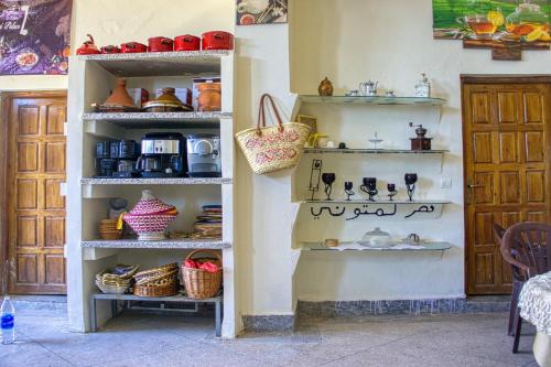 a shelf filled with dishes and baskets on a wall at lmtounipalace in Ouarzazate