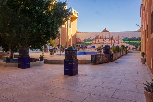 a street with a fence and trees and a building at lmtounipalace in Ouarzazate