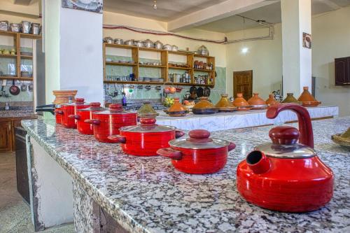 a group of red pots sitting on a counter in a room at lmtounipalace in Ouarzazate